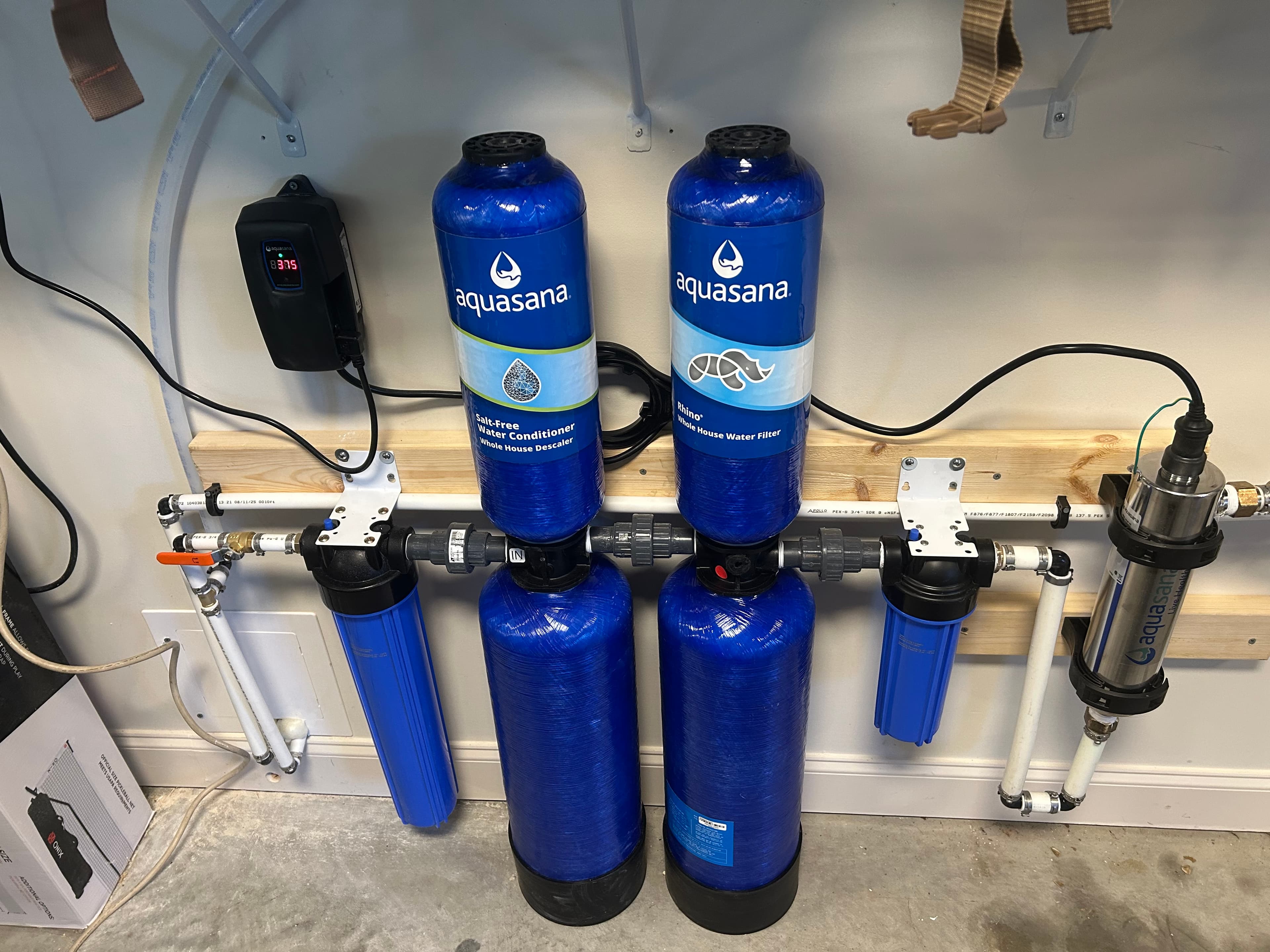 Aquasana whole house water filtration and descaler system with blue tanks and white piping.